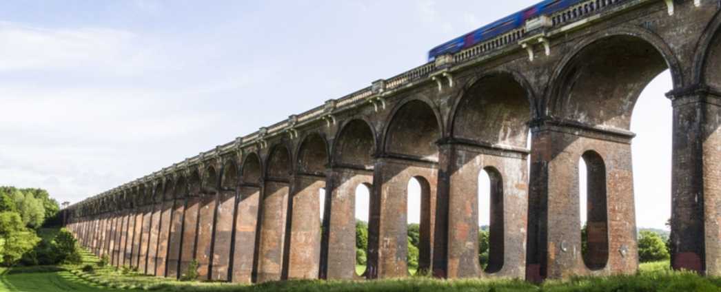 A train going over an arched bridge.